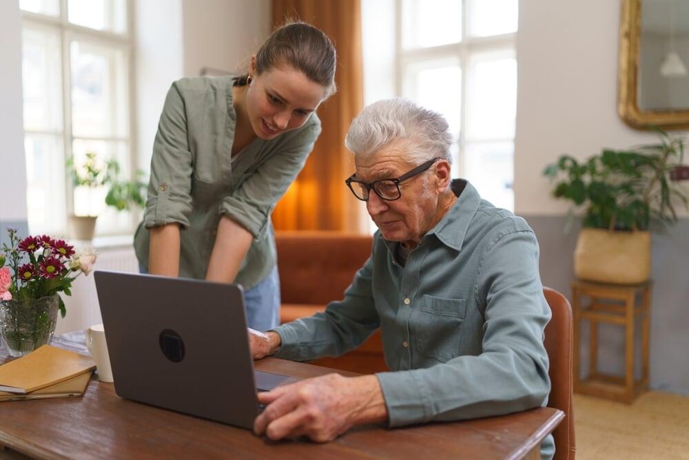 Un jeune conseiller Finox soutient un client plus âgé dans ses démarches financières, soulignant l'importance de la vision à long terme et de la planification successorale.